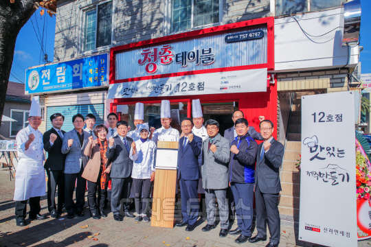 호텔신라의 사회공헌활동 '맛있는 제주 만들기' 의 12호점인 청춘테이블 앞에서 관계자들이 파이팅을 외치고 있다. 호텔신라 제공